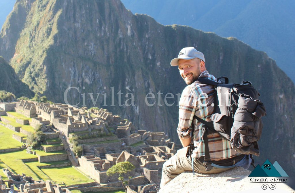 Manuel Bonoli seduto sui terrazzamenti di Machu Picchu vicino alla casa del guardiano con le rovine della città sullo sfondo